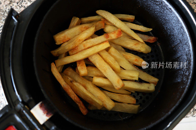 在空气炸锅里炸出的金黄色、新鲜、酥脆的薯条/大块薯条，是更健康的零食烹饪选择